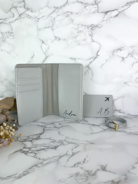 Personalisierte Reisepasshülle mit Kofferanhänger, hellgrau, veganes Leder, mit Name und Initialen bedruckt.