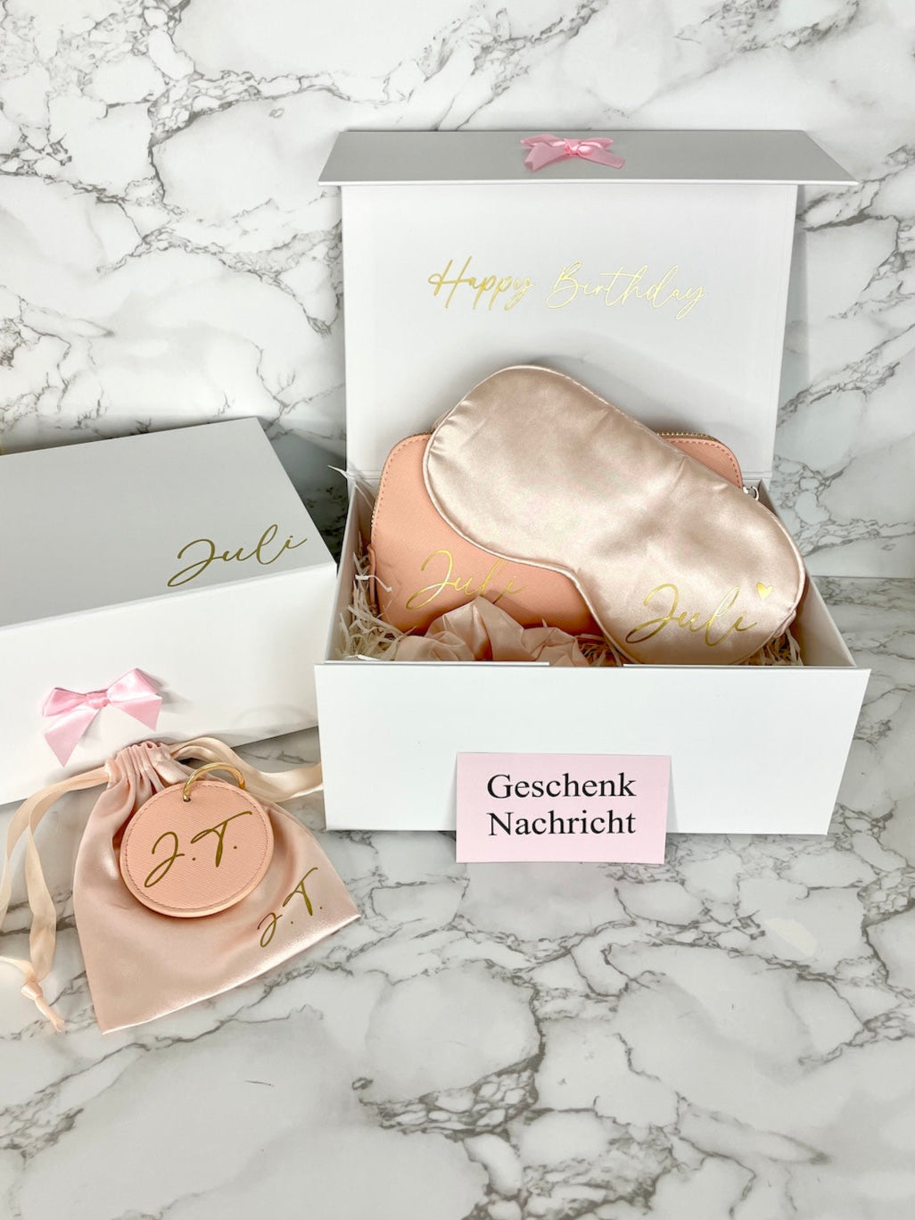 Personalisierte Geschenkbox für Frauen mit Kosmetiktasche, Schlafmaske, Scrunchie und Schlüsselanhänger in Rosa.