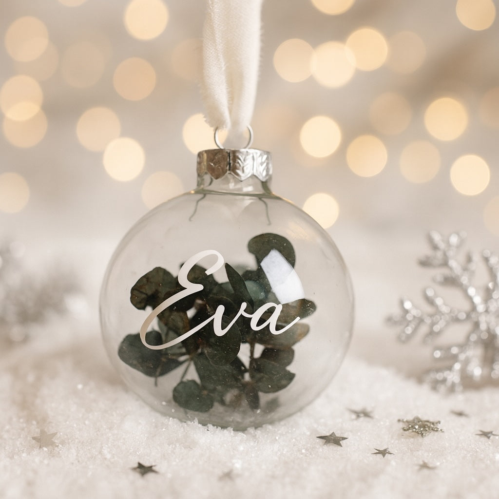 Glas-Weihnachtskugel mit Eukalyptusfüllung und personalisiertem Namen Eva, dekoriert mit weißem Stoffband und Weihnachtsdeko – individuelles Weihnachtsgeschenk für Frau, Mama, Oma oder Eltern.