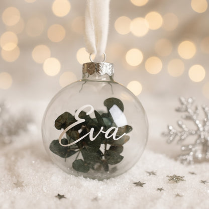 Glas-Weihnachtskugel mit Eukalyptusfüllung und personalisiertem Namen Eva, dekoriert mit weißem Stoffband und Weihnachtsdeko – individuelles Weihnachtsgeschenk für Frau, Mama, Oma oder Eltern.