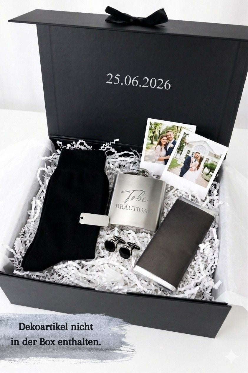 Geöffnete personalisierte Geschenkbox für den Bräutigam mit Datum im Deckel, dekoriert mit Socken, Flachmann, Fotos und Manschettenknöpfen als Beispiel für mögliche Befüllung.