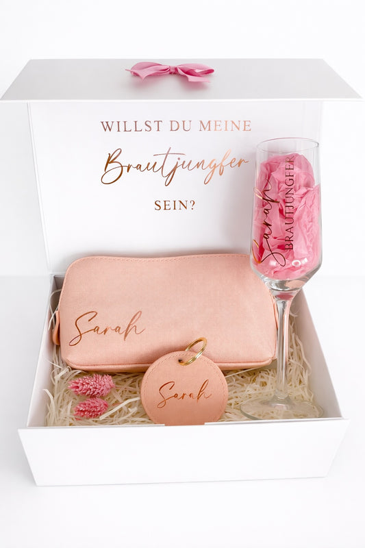Personalisierte Brautjungfer Geschenkbox mit Aufdruck ‚Willst du meine Brautjungfer sein?‘, Sektglas, Kosmetiktasche und Schlüsselanhänger mit Name Sarah in Roségold.