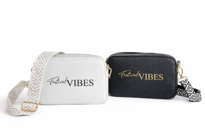 Zwei Damen Umhängetaschen „Festival Vibes“ in Schwarz und Grau mit breitem Taschengurt auf hellem neutralem Hintergrund.