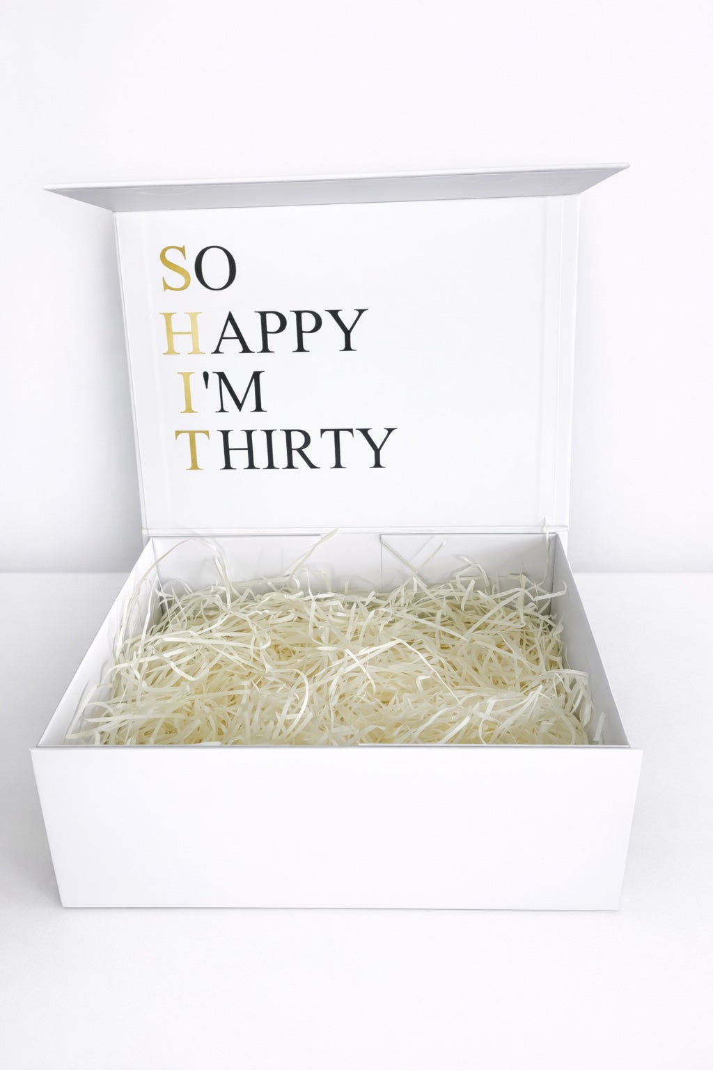 Offene weiße Geschenkbox zum 30. Geburtstag mit Schriftzug „SO HAPPY I’M THIRTY“ und Papierfüllung auf hellem Hintergrund