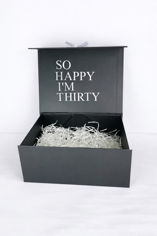 Schwarze Geschenkbox für Männer mit Aufdruck "So happy I'm thirty" geöffnet mit Füllmaterial