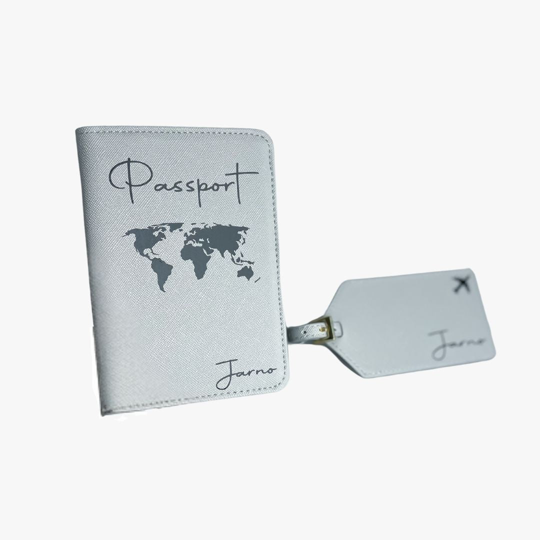 Personalisierte graue Reisepasshülle mit Weltkarten-Design und Schriftzug „Passport“ sowie passendem Kofferanhänger mit Flugzeugsymbol und Namen „Jarno“, aus veganem Saffiano-Leder.