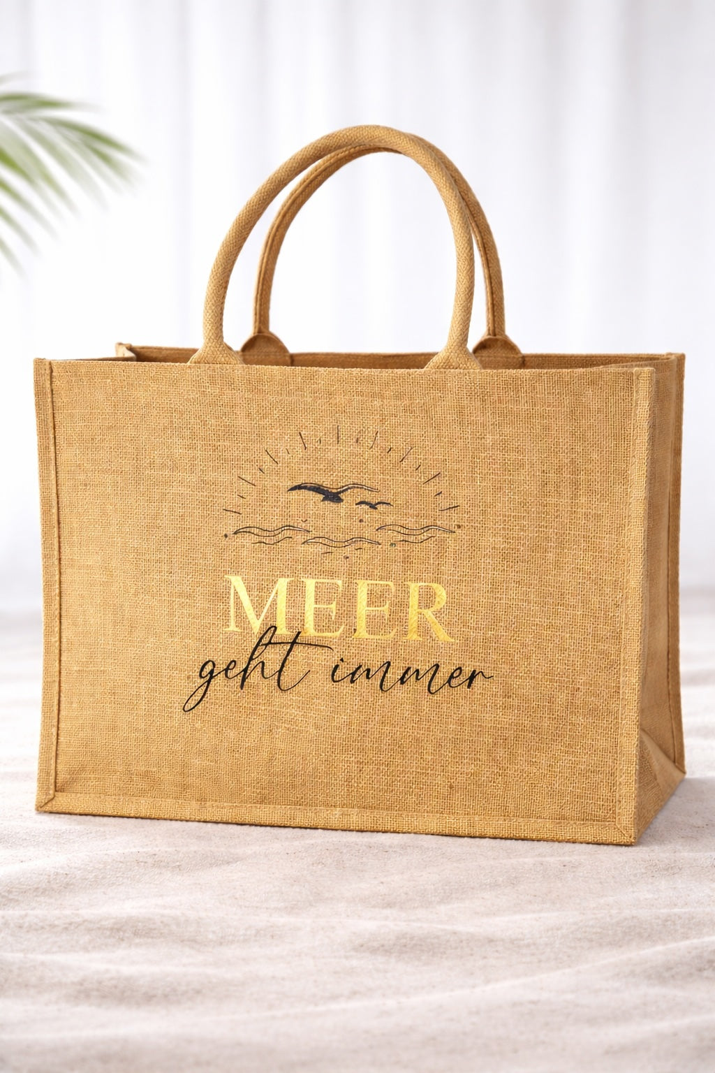 Jute Strandtasche mit Aufdruck „Meer geht immer“, Schriftzug MEER in Gold vor hellem neutralem Hintergrund, natürliche Beach Bag mit stabilen Griffen.