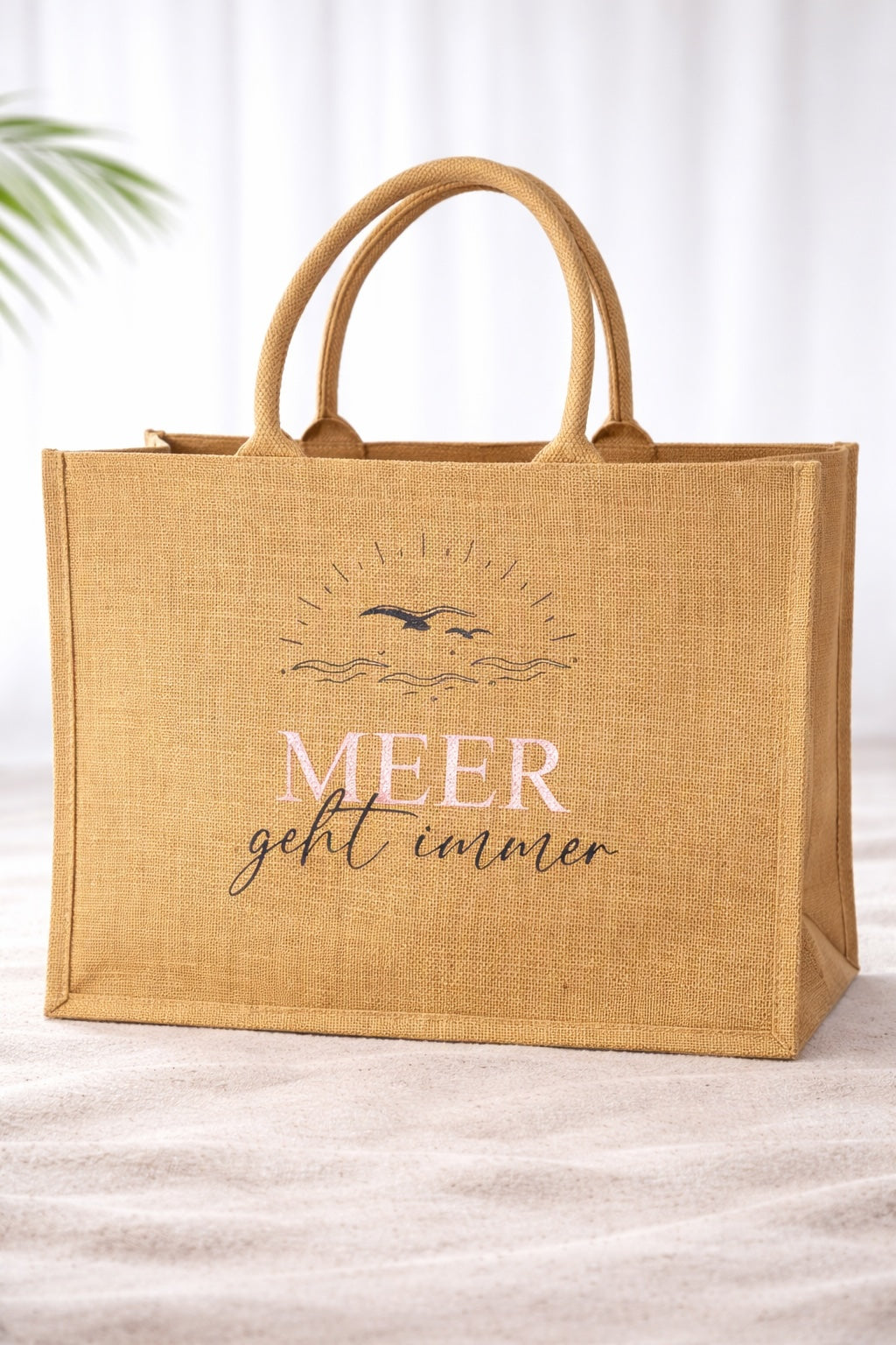 Jute Strandtasche mit Aufdruck „Meer geht immer“ in Roségold vor hellem neutralem Hintergrund, natürliche Beach Bag mit stabilen Griffen.
