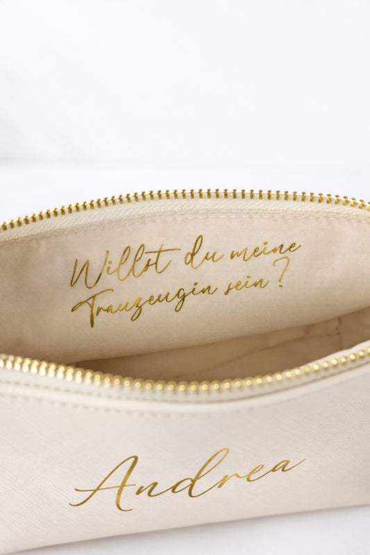 Detailaufnahme der personalisierten Kosmetiktasche mit der Aufschrift „Willst du meine Trauzeugin sein?“ in Gold.