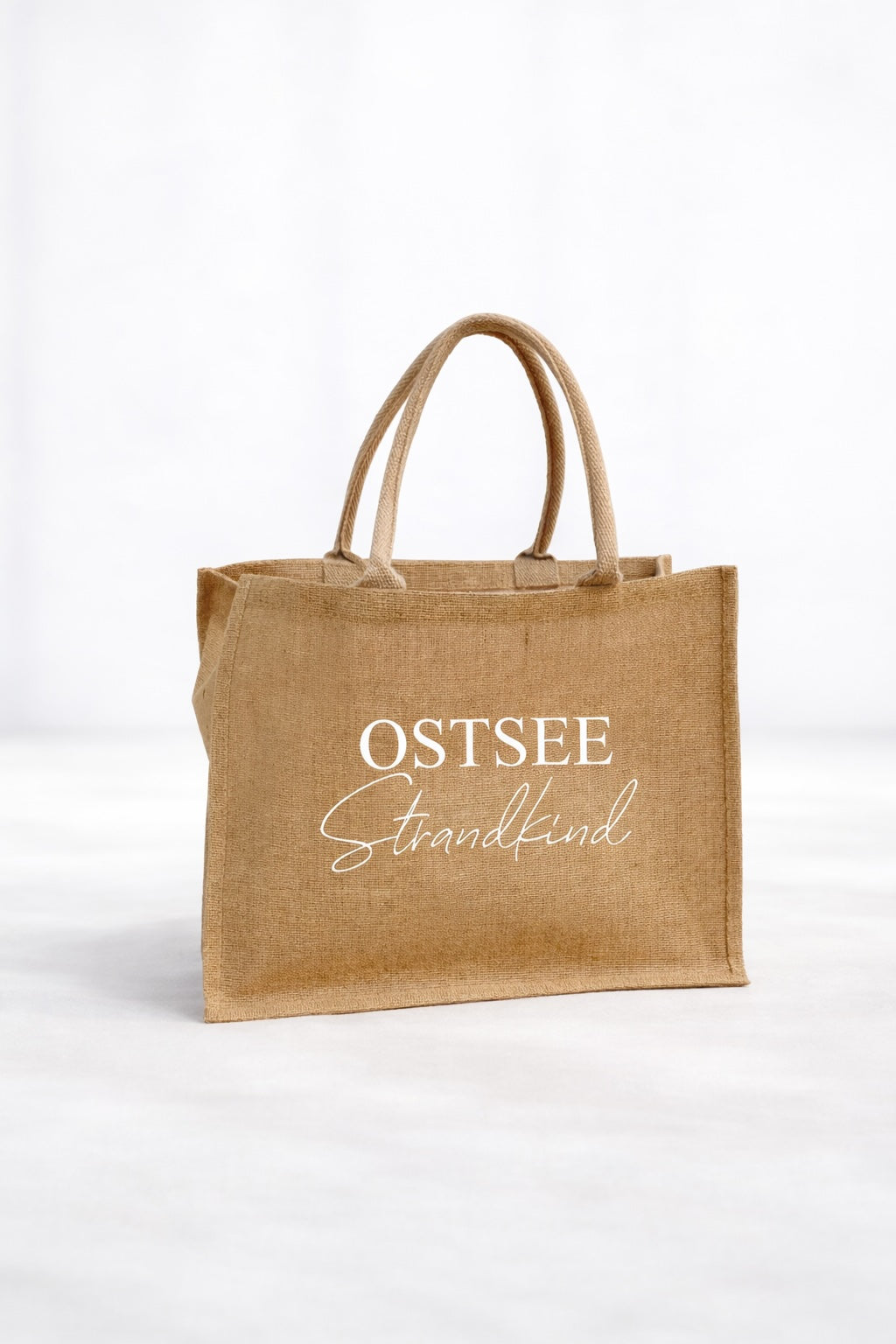 Jute Strandtasche „Ostsee Strandkind“ in Naturfarbe mit weißem Aufdruck, personalisierbar mit Namen, neutrale helle Produktaufnahme