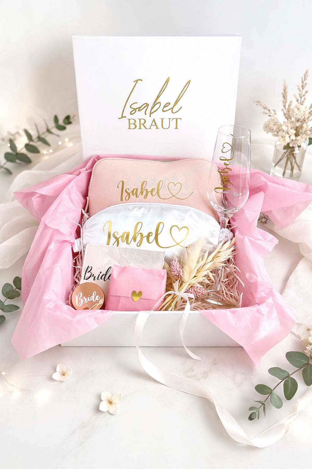 Personalisierte Braut Geschenkbox mit Kosmetiktasche, Schlafmaske, Champagnerglas und kleinen Accessoires für das Getting Ready der Braut.
