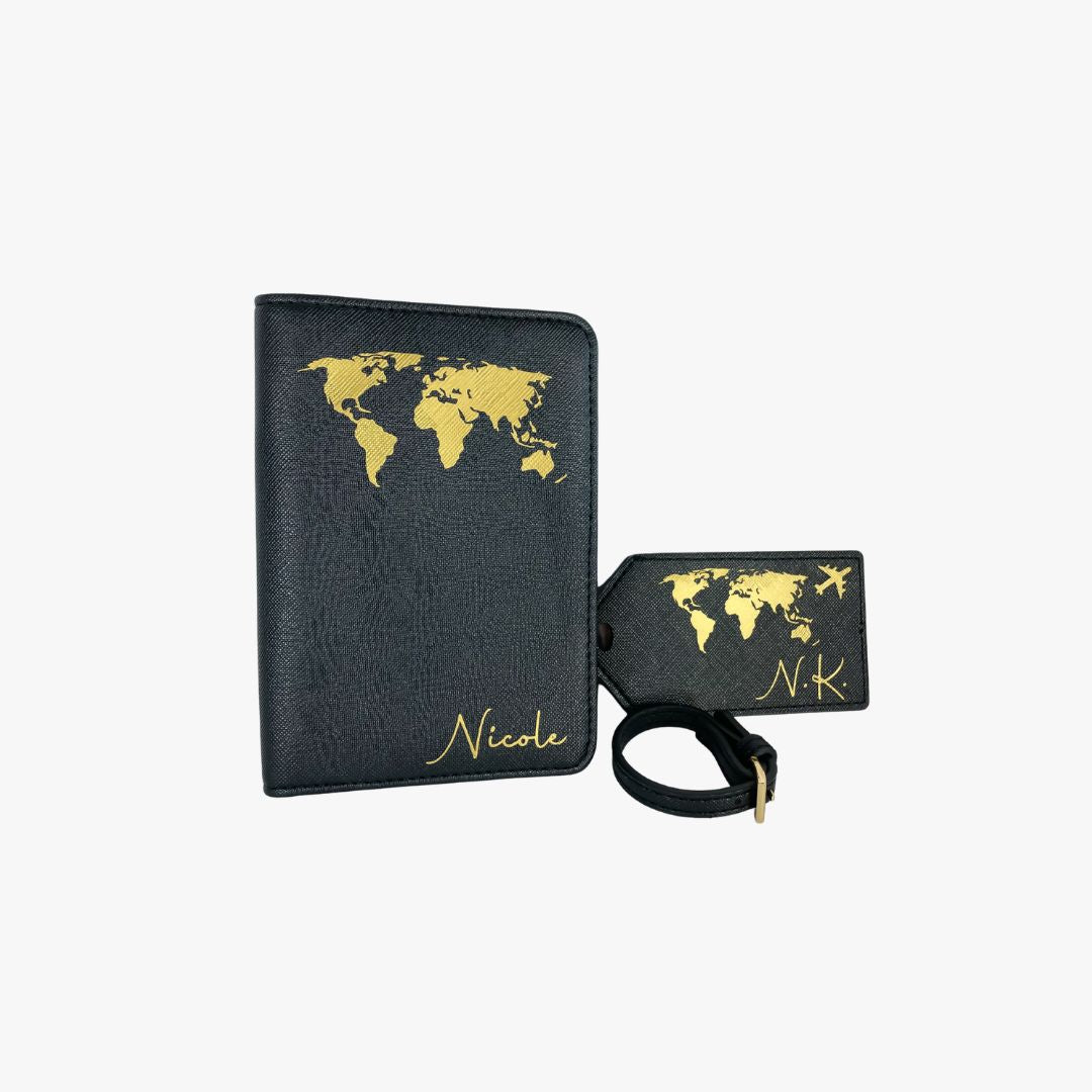 Personalisierte schwarze Reisepasshülle mit goldenem Weltkarten-Design und passendem Kofferanhänger. Die Hülle ist mit dem Namen ‚Nicole‘ versehen, der Anhänger mit den Initialen ‚N.K.‘