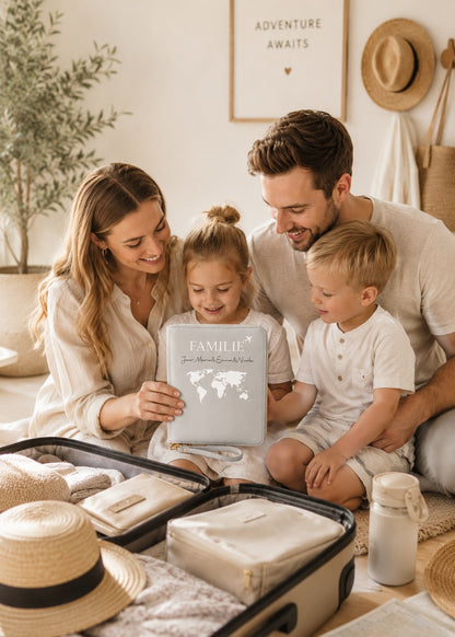 Glückliche Familie bei der Reisevorbereitung mit personalisiertem grauen Reiseorganizer vor einem geöffneten Koffer.