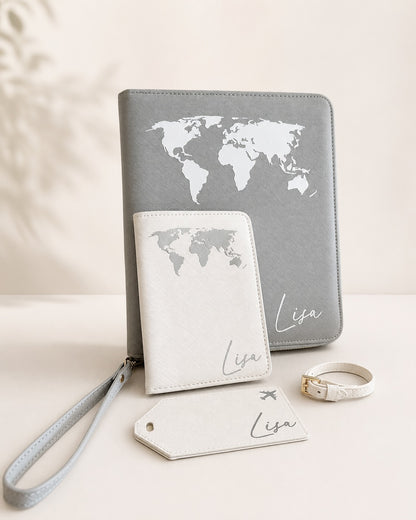 Personalisiertes Reiseaccessoire-Set mit grauem Reiseetui, weißer Reisepasshülle, Kofferanhänger und Namensaufdruck Lisa auf hellem neutralem Hintergrund.