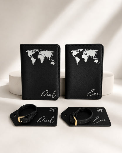 Personalisiertes Reisepasshüllen-Set in Schwarz mit weißem Weltkarten-Aufdruck, bestehend aus zwei Reisepasshüllen und passenden Kofferanhängern mit den Namen Paul und Eva auf hellem, neutralem Hintergrund.