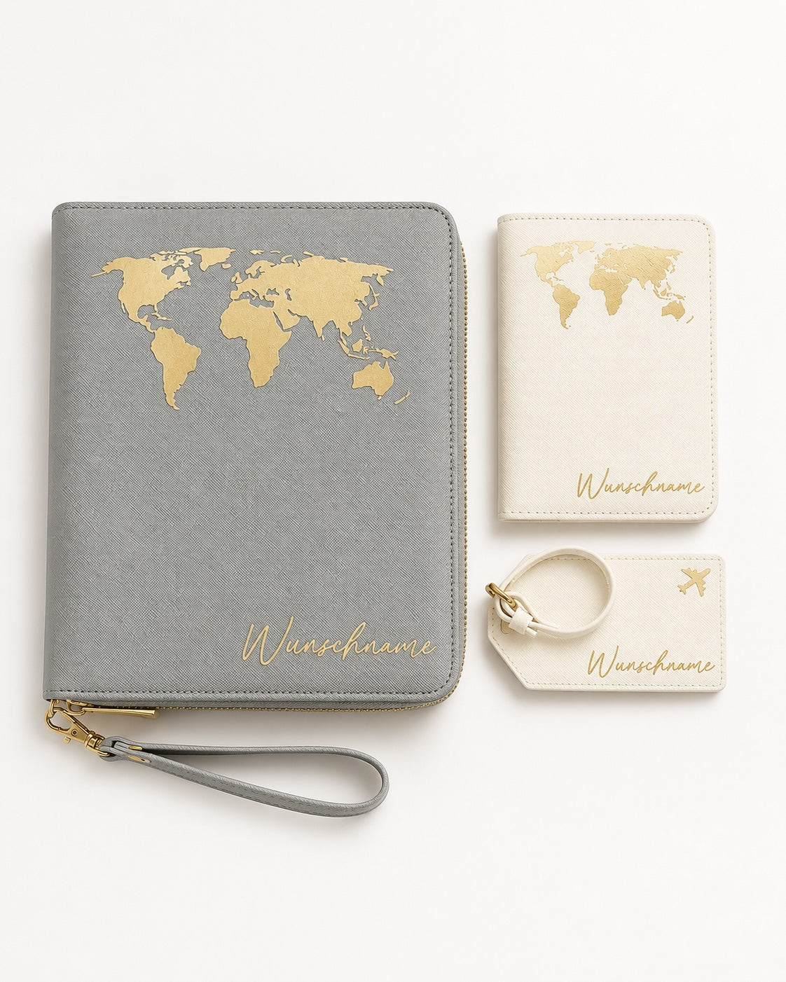 Flatlay eines personalisierten Reiseaccessoire-Sets mit grauem Reiseetui, cremefarbener Reisepasshülle und Kofferanhänger, jeweils mit goldener Weltkarten-Grafik und Namensaufdruck, sauber arrangiert auf hellem neutralem Hintergrund.