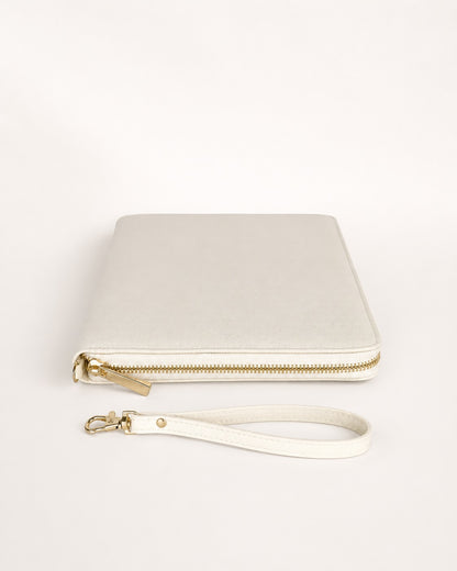 Produktbild eines beigen Reiseorganizers mit goldfarbenem Reißverschluss und passender Handschlaufe auf hellem, neutralem Hintergrund. Der Organizer ist geschlossen und minimalistisch für einen Online-Shop dargestellt.
