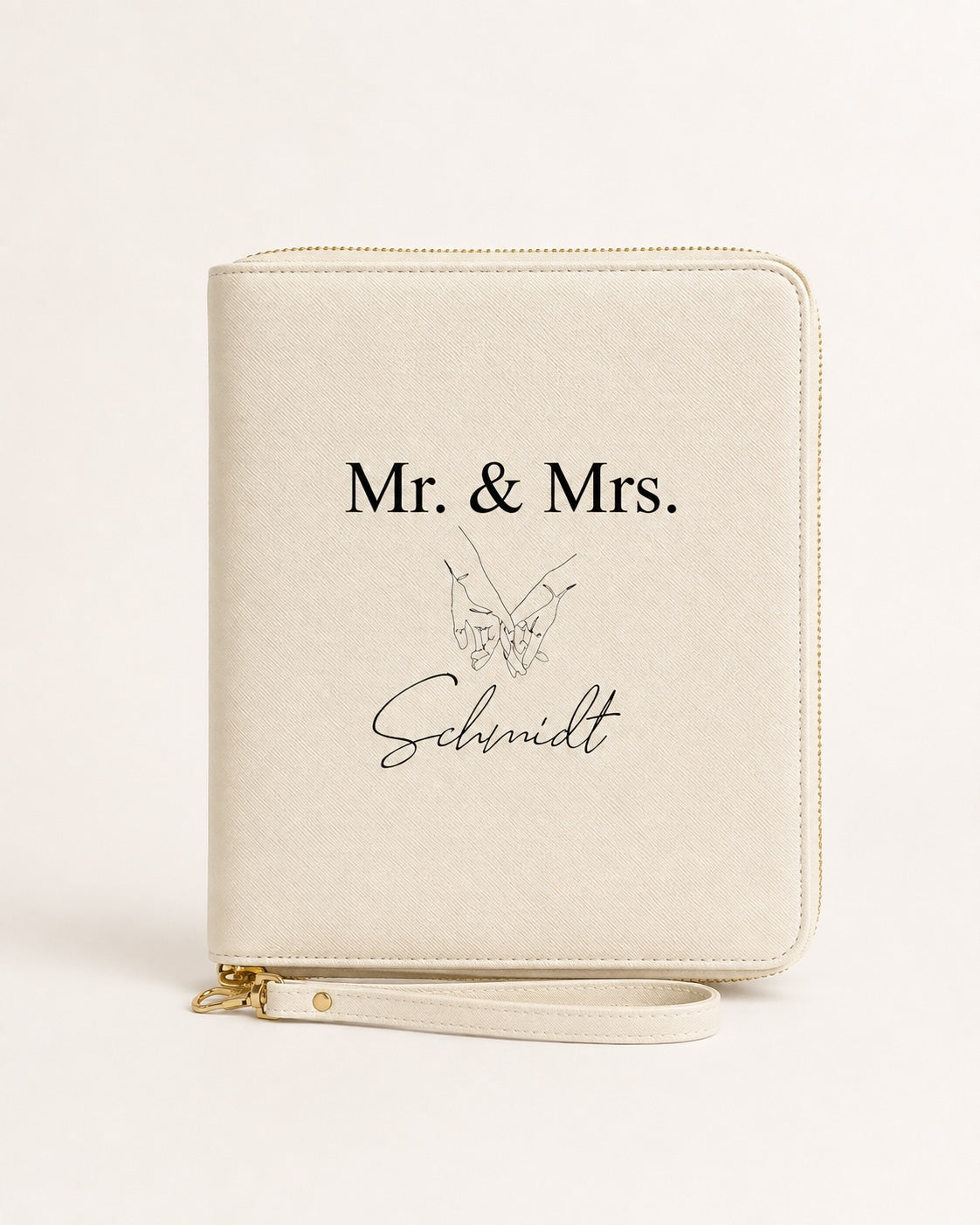 Personalisierter beiger Reiseorganizer mit „Mr. & Mrs. Schmidt“, schwarzem Handmotiv und goldenen Details auf neutralem Hintergrund.