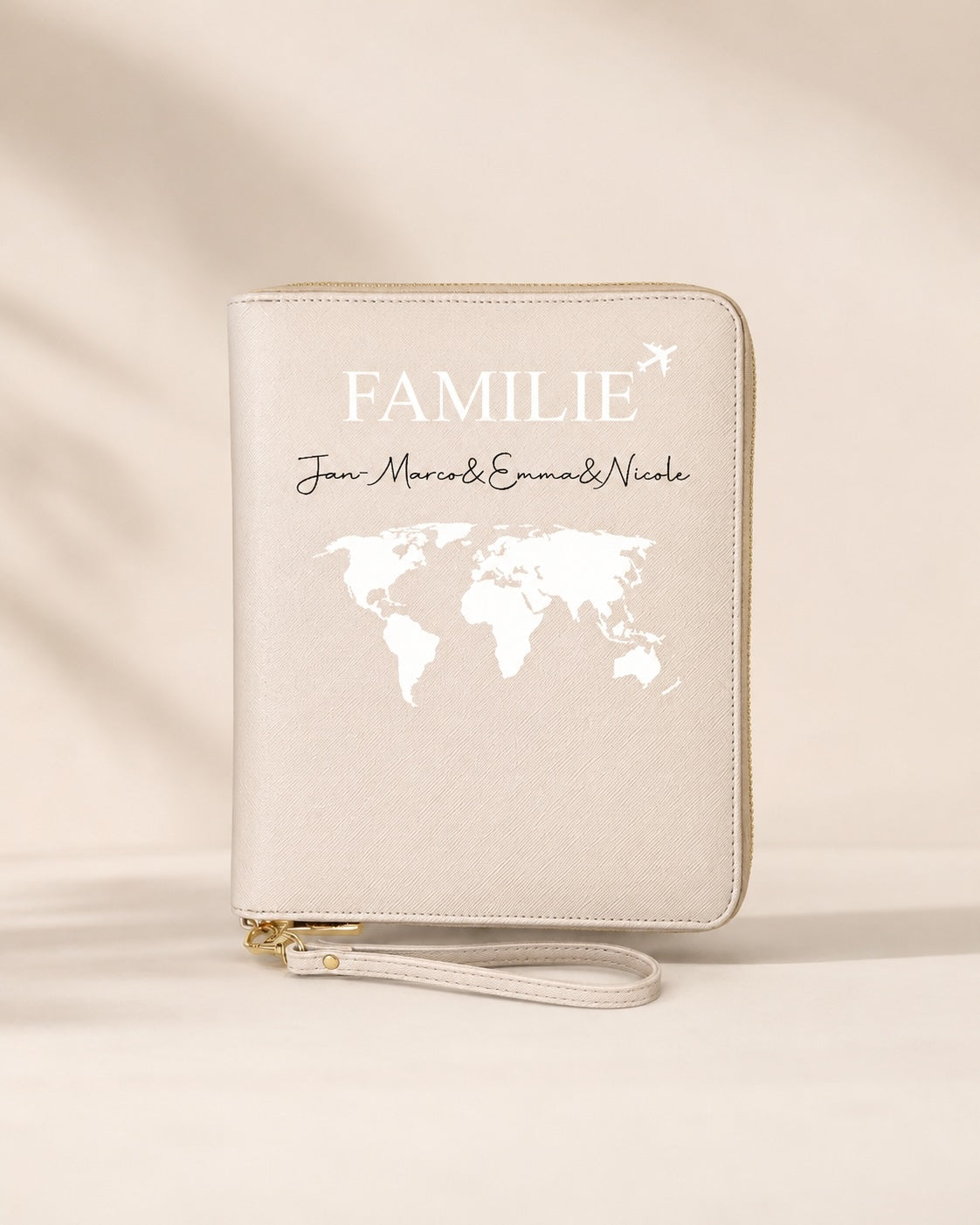 Beiger personalisierter Reiseorganizer für Familien mit weißem Aufdruck, Weltkarte und individuellen Namen vor neutralem Hintergrund.