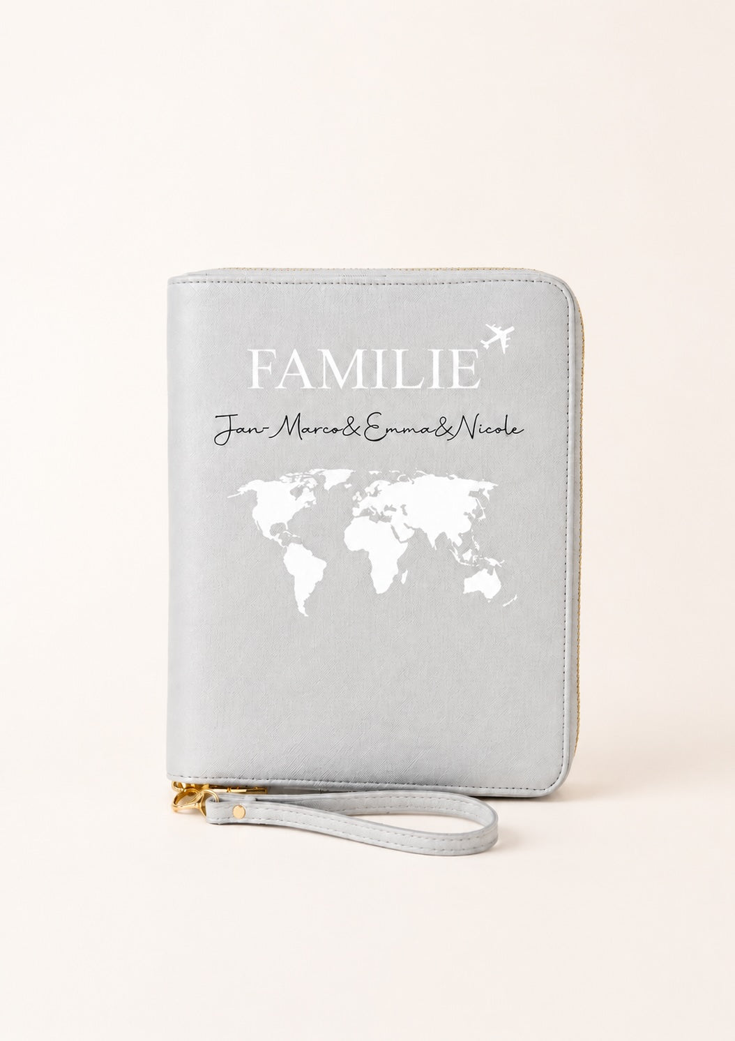 Personalisierter grauer Reiseorganizer mit Familienmotiv, Weltkarte und den Namen „Jan-Marcos, Emma & Nicole“ auf einem hellen, warmen Beigeton. Das Produkt steht im Mittelpunkt und wird vor einem schlichten, neutralen Hintergrund präsentiert.