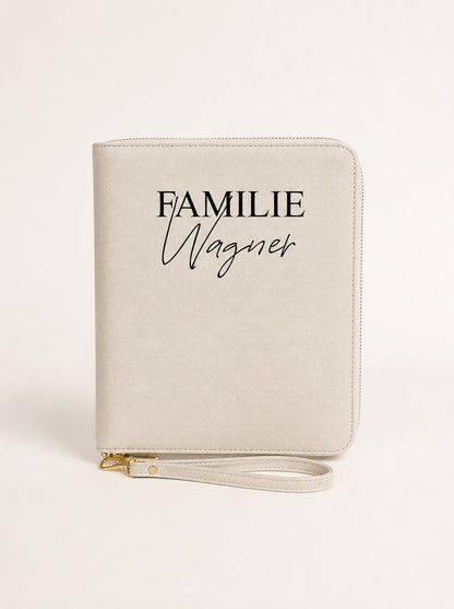 Personalisierter Reiseorganizer in Beige mit schwarzem Aufdruck „Familie Wagner“ vor neutralem Hintergrund.