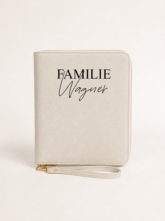 Personalisierter Reiseorganizer in Beige mit schwarzem Aufdruck „Familie Wagner“ vor neutralem Hintergrund.