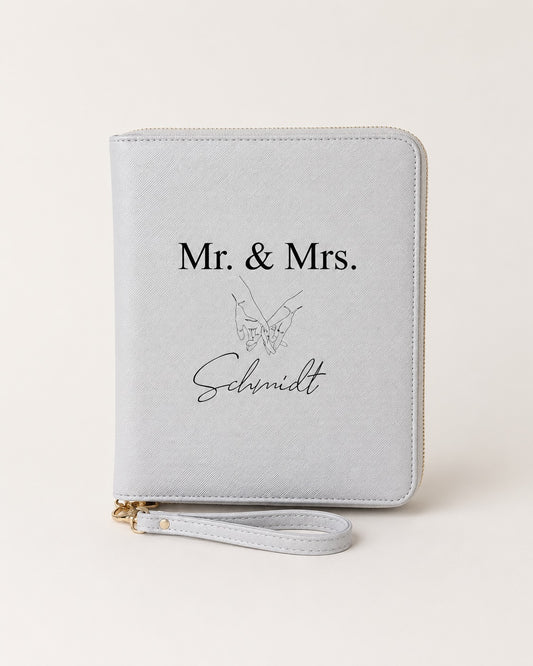 Personalisierter hellgrauer Reiseorganizer mit „Mr. & Mrs. Schmidt“, Handmotiv und schwarzem Aufdruck auf neutralem Hintergrund.