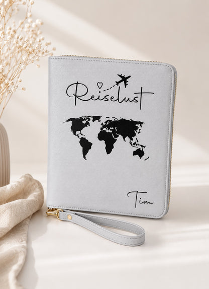Grauer personalisierter Reiseorganizer mit schwarzem Schriftzug „Reiselust“, schwarzer Weltkarte und dem Namen Tim vor hellem, ästhetischem Hintergrund.