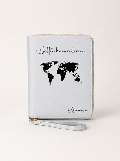Hellgrauer personalisierter Reiseorganizer mit schwarzer Weltkarte, dem Schriftzug „Weltenbummlerin“ und dem Namen Andrea vor neutralem Hintergrund.