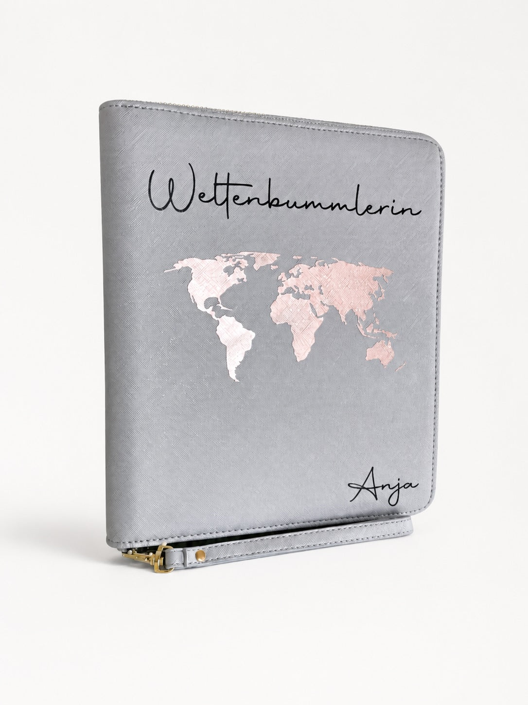 Grauer personalisierter Reiseorganizer mit rosafarbener Weltkarte, schwarzem Schriftzug „Weltenbummlerin“ und dem Namen Anja vor hellem Hintergrund.