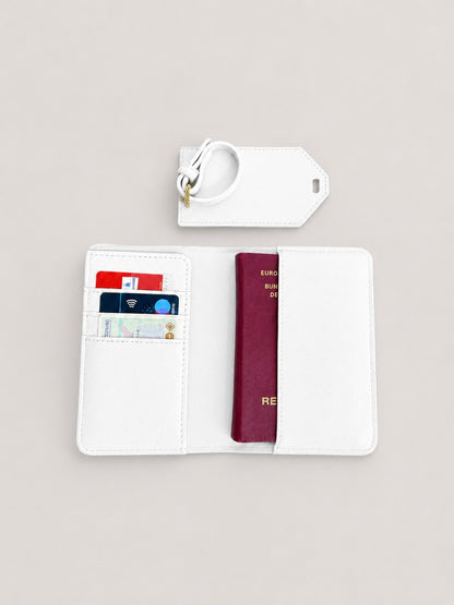 Minimalistisches Produktfoto einer weißen Reisepasshülle mit Kofferanhänger und Dokumentenmappe auf hellem, neutralem Hintergrund, mit sichtbarer Karte und Kartenfächern im Inneren.