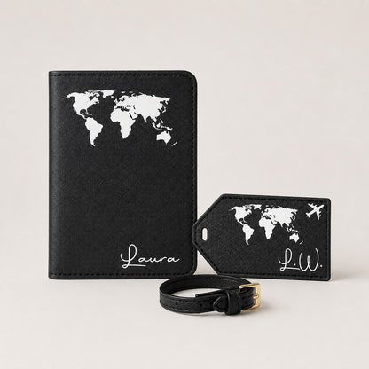 Ästhetisches Hauptbild eines personalisierten Reiseaccessoire-Sets in Schwarz mit weißem Weltkartenmotiv. Zu sehen sind eine Reisepasshülle, ein passender Kofferanhänger mit kleinem Flugzeug und eine schwarze Schlaufe auf neutralem, einfarbigem Hintergrund.