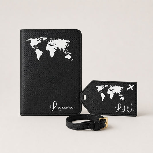 Ästhetisches Hauptbild eines personalisierten Reiseaccessoire-Sets in Schwarz mit weißem Weltkartenmotiv. Zu sehen sind eine Reisepasshülle, ein passender Kofferanhänger mit kleinem Flugzeug und eine schwarze Schlaufe auf neutralem, einfarbigem Hintergrund.