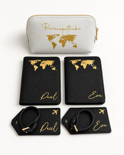 Produktbild eines personalisierten Reisesets mit hellgrauer Reiseapotheke, schwarzen Passhüllen und Kofferanhängern mit goldfarbenem Aufdruck vor hellem Hintergrund.