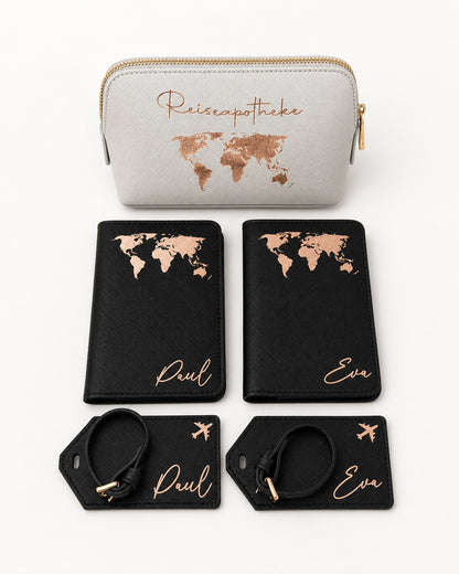 Produktbild eines personalisierten Reisesets mit hellgrauer Reiseapotheke, schwarzen Passhüllen und Kofferanhängern mit roségoldenem Aufdruck vor hellem Hintergrund.
