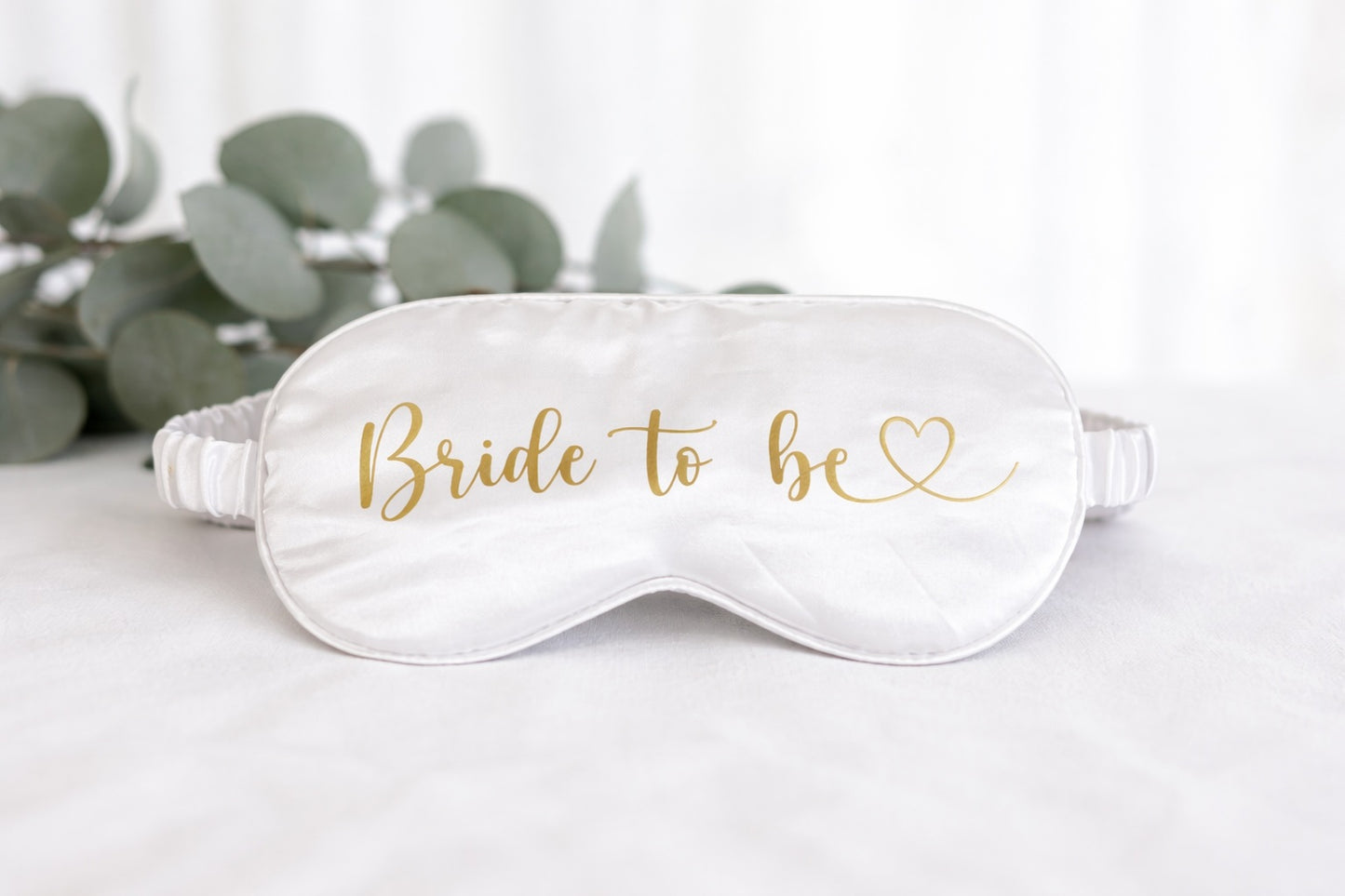 Weiße Schlafmaske mit goldener Aufschrift „Bride to be“ für das Getting Ready der Braut am Hochzeitstag.