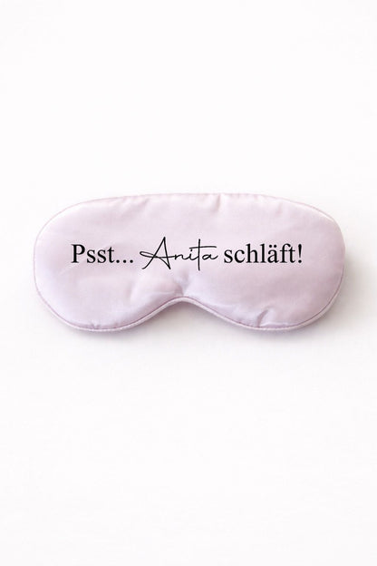Personalisierte lila Schlafmaske mit Aufdruck „Psst… Anita schläft“ vor hellem, neutralem Hintergrund