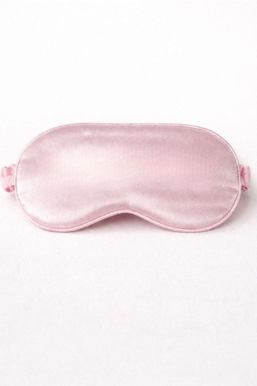 Rosa Schlafmaske aus Satin ohne Aufdruck, schlichtes Produktfoto vor hellem Hintergrund