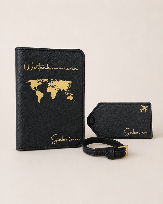 Schwarzes Reiseaccessoire-Set mit personalisierter Reisepasshülle, passendem Kofferanhänger und Gepäckriemen. Das Set ist mit goldfarbenem Weltkartenmotiv, Flugzeug-Symbol, dem Schriftzug „Weltenbummlerin“ und dem Namen „Sabrina“ verziert. Neutraler Hintergrund, Produkt im Mittelpunkt.