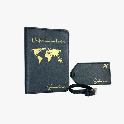 Personalisierte schwarze Reisepasshülle mit goldener Weltkarte und Schriftzug „Weltenbummlerin“ sowie passendem Kofferanhänger mit Flugzeugsymbol und Namen „Sabrina“, aus veganem Saffiano-Leder.