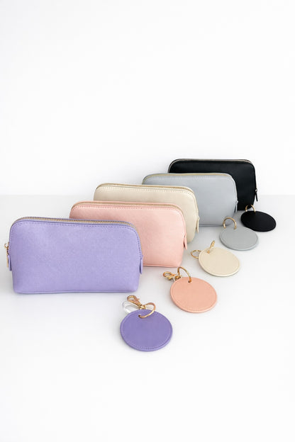 Trauzeugin Geschenkbox mit Kosmetiktasche und passendem Schlüsselanhänger in mehreren Farben auf hellem, minimalistischem Hintergrund.