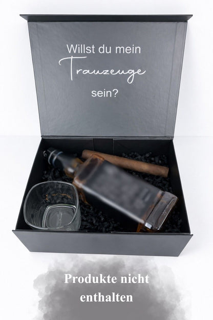Offene Trauzeugen-Geschenkbox mit der Aufschrift ‚Willst du mein Trauzeuge sein?‘, mit Glas und unkenntlich gemachter Flasche auf hellem Hintergrund.