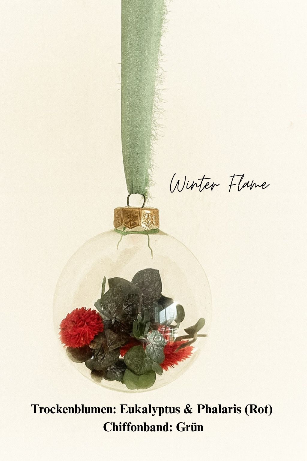 Personalisierte Weihnachtskugel aus Glas mit goldenem Kranz und grünen Chiffon-Aufhänger, gefüllt mit roten Phalaris-Trockenblumen und grünem Eukalyptus, Variante ‚Winter Flame‘.